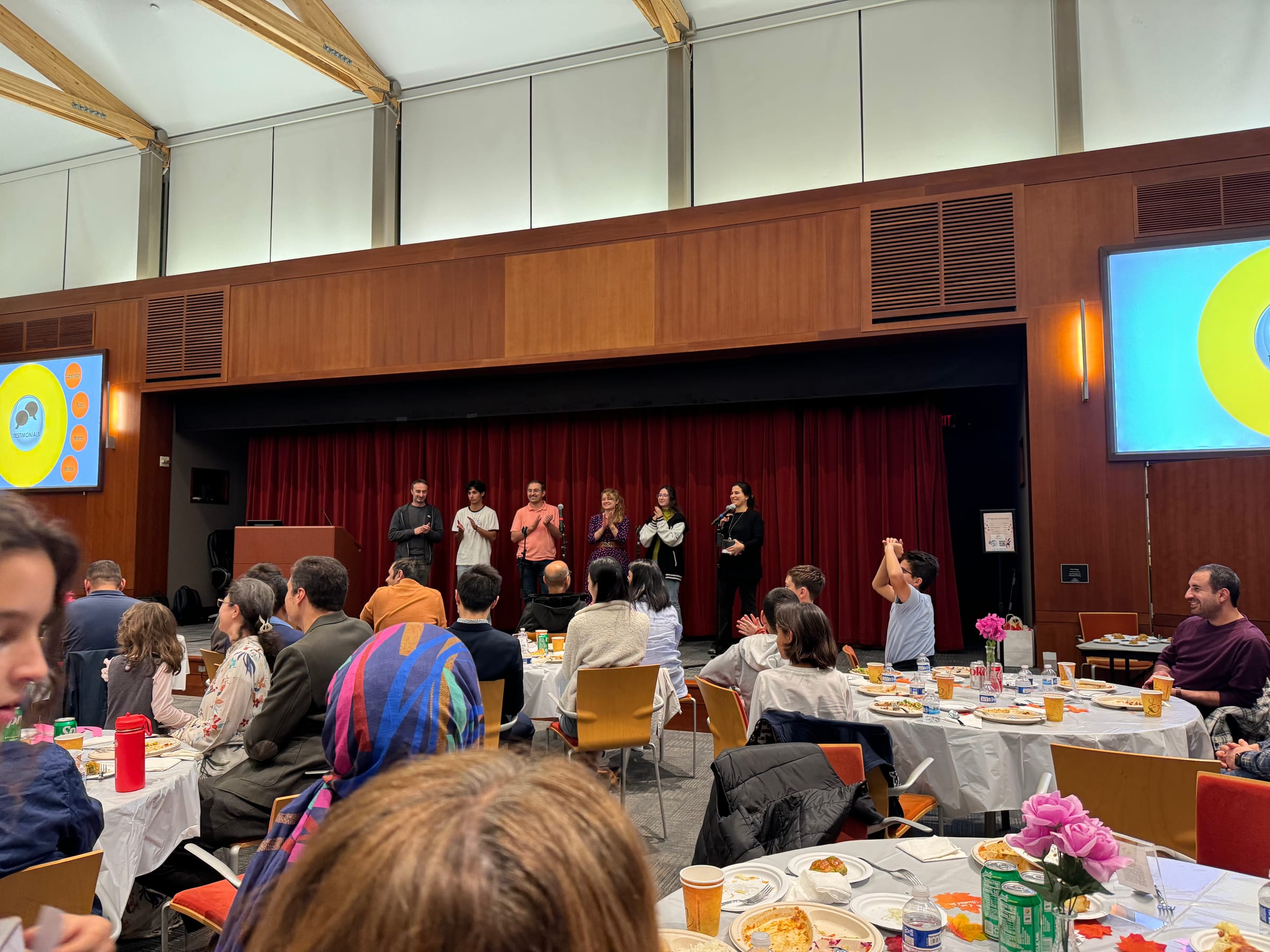 IT Society volunteers applauded on stage at a community dinner